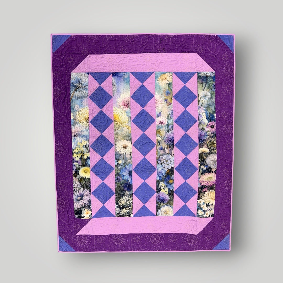 Quilt with purple and pink diamond pattern and floral inserts on a light gray background Lovely Flowers Quilt Kit Finished Size - Northcott/Timeless Treasures Fabric 49.75" x 60" -Carmons Quilt Shop 2