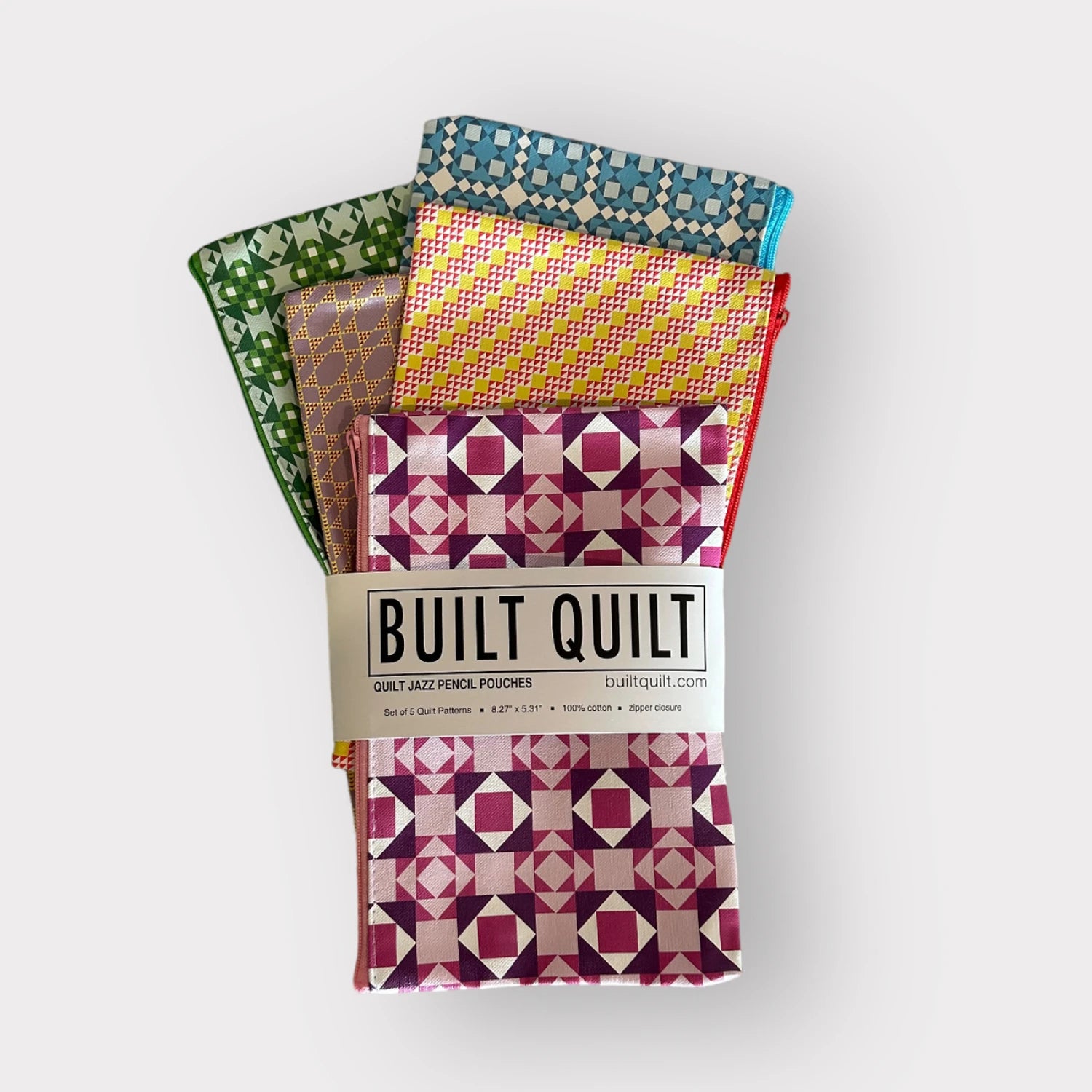 Packaged quilt-style pencil pouches with colorful patterns on a white background