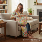 Carmon's Quilt Shop woman sitting on a couch holding a tote bag made from multi-colored abstract splatter cotton fabric
