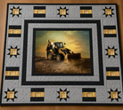 Carmon's Quilt Shop Backhoe Loader quilt kit featuring a construction panel with grey, black, and gold star borders.