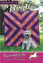 Carmon's Quilt Shop Birdie quilt pattern featuring a geometric purple and floral design with a dog sitting in front