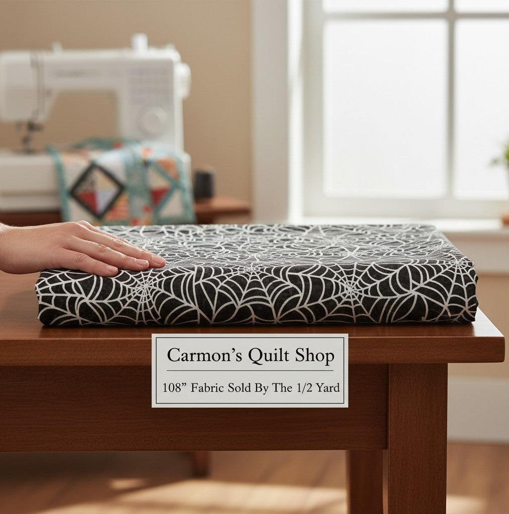 Carmon's Quilt Shop black cotton fabric with white spiderweb print for Halloween quilting projects