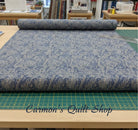 Carmon's Quilt Shop Meadow Breeze blue floral 108-inch wide cotton quilt backing fabric on a cutting mat.