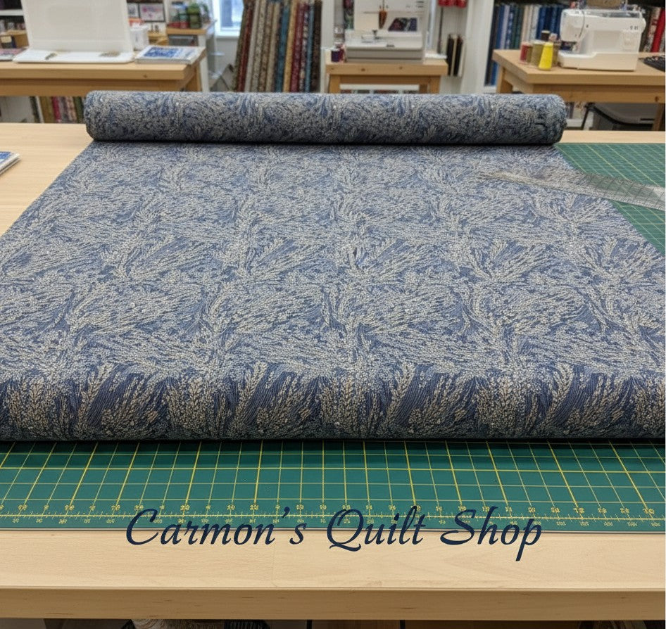 Carmon's Quilt Shop Meadow Breeze blue floral 108-inch wide cotton quilt backing fabric on a cutting mat.