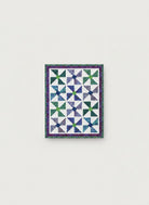 Carmon's Quilt Shop Fabric Café Bold in Bloom lap quilt with blue and green pinwheel blocks on a white background.