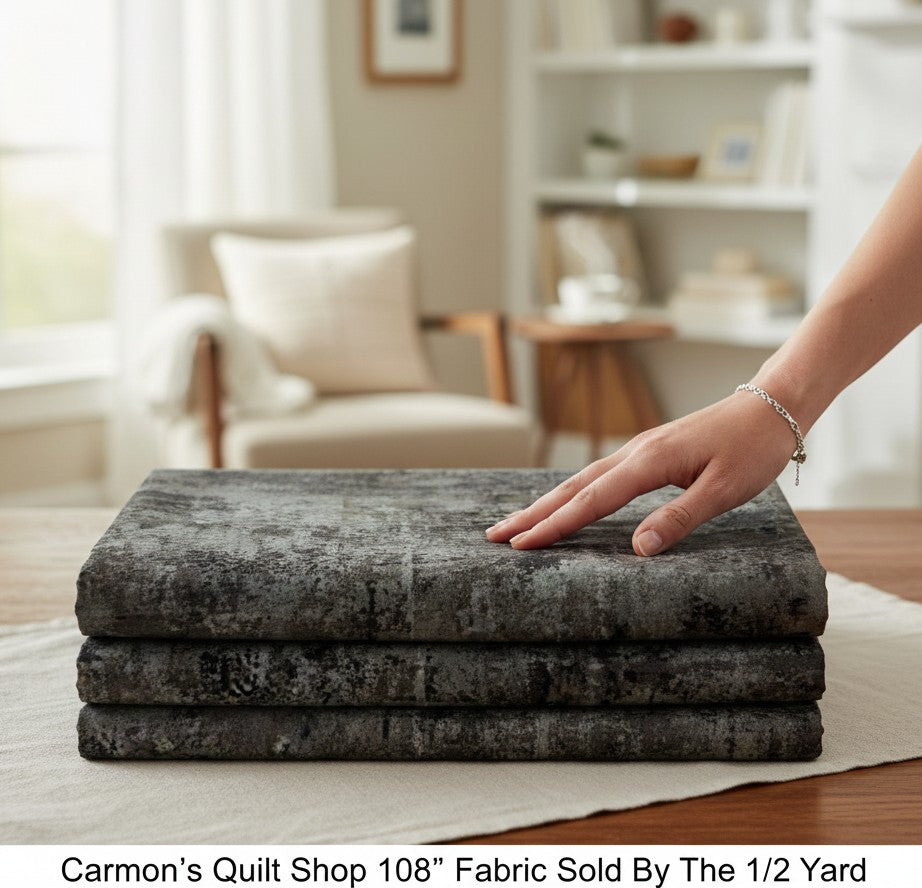 Carmon's Quilt Shop charcoal mottled blender 108-inch wide quilting cotton fabric folded on a table