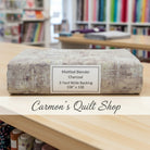 Carmon's Quilt Shop charcoal mottled blender 108-inch wide cotton quilt backing fabric folded on a wooden table.