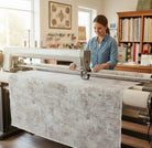 Carmon's Quilt Shop features a woman using a longarm machine to quilt mottled charcoal 108-inch wide cotton backing.