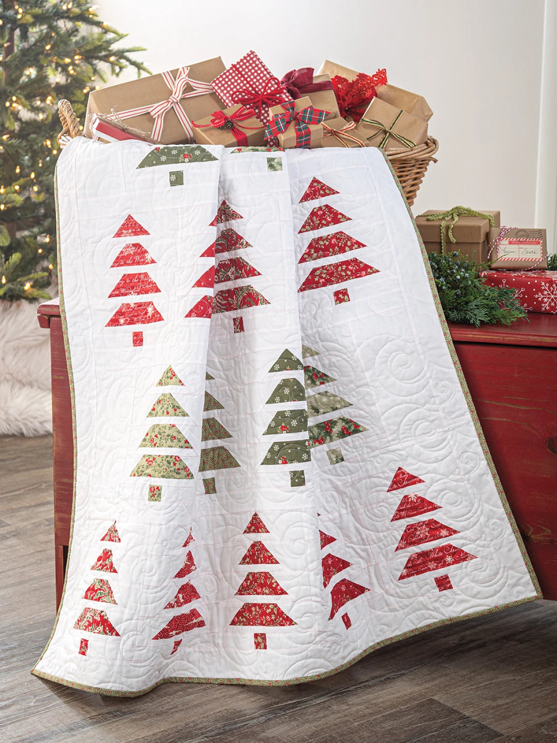 Carmon's Quilt Shop holiday quilt featuring red and green fabric Christmas tree patterns on a white quilted background