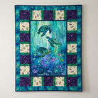 Carmon's Quilt Shop Coral Reef cotton fabric panel featuring sea turtles and fish in shades of blue, green, and purple.