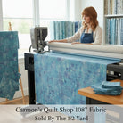 Carmon's Quilt Shop 108 inch denim blue mottled cotton blender fabric being used on a longarm quilting machine