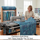 Carmon's Quilt Shop denim blue mottled 108-inch wide cotton quilting fabric on a longarm machine in a sewing studio.