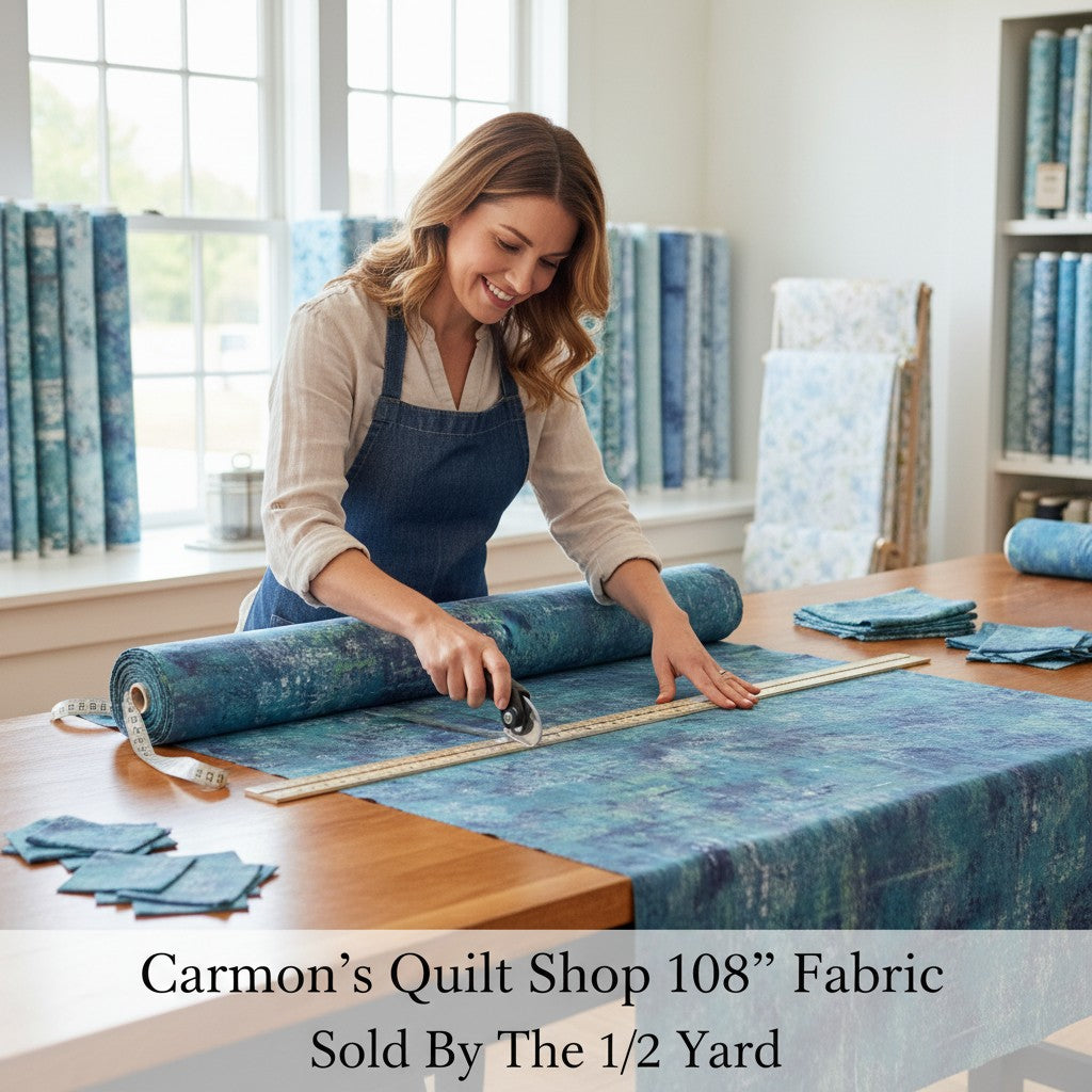 Carmon's Quilt Shop woman cutting denim blue mottled 108 inch wide cotton quilting fabric on a wooden table