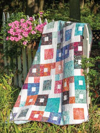 Carmon's Quilt Shop Forever Fabulous Fat Quarter quilt featuring colorful pieced squares on a white picket fence.