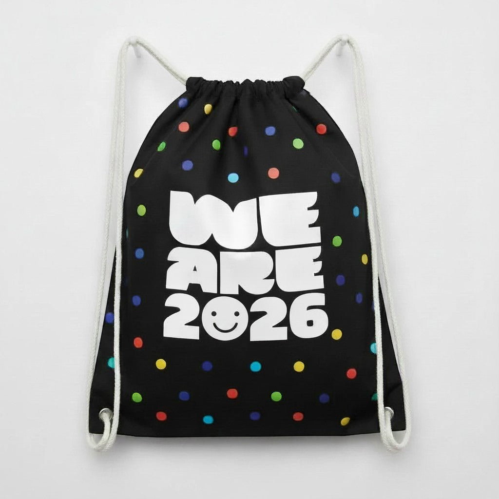 Carmon's Quilt Shop black drawstring backpack with colorful polka dots and "WE ARE 2026" text.