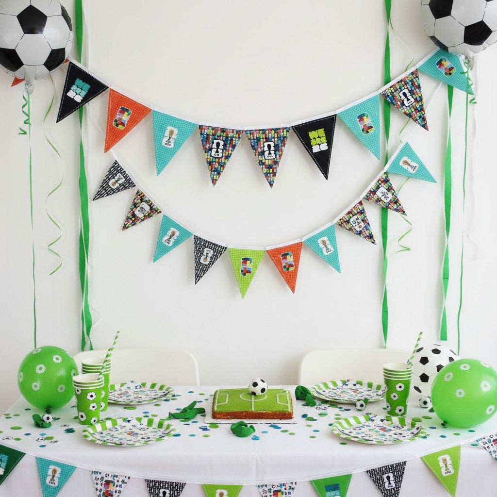 Carmon's Quilt Shop FIFA World Cup fabric panel with geometric pennants in green, orange, black, and teal featuring soccer motifs.