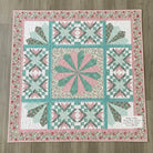 Carmon's Quilt Shop Floating Dresden quilt kit in floral pink and teal cotton fabric with intricate pieced patterns.