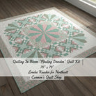Carmon's Quilt Shop Floating Dresden quilt kit in floral cotton fabrics with pink and green tones on wood floor.