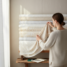 Carmon's Quilt Shop employee selecting Light As Air floral cotton fabric from a stack of rolls in a bright studio