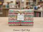 Carmon's Quilt Shop Quilting in Bloom 13-piece floral cotton fat quarter bundle tied with twine and a price tag.