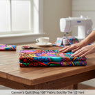 Carmon's Quilt Shop 108-inch wide cotton fabric with vibrant floral and geometric patterns on a black background.