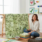 Carmon's Quilt Shop Got Your Back leaf print 108-inch wide cotton fabric displayed on a quilt rack by a crafter.