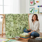 Carmon's Quilt Shop wide green botanical leaf and dragonfly print cotton fabric draped on a quilting frame