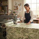 Carmon's Quilt Shop woman using a longarm machine to quilt green botanical leaf print 108-inch wide cotton fabric