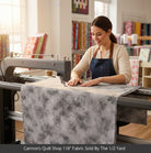 Carmon's Quilt Shop 118 inch grey mottled cotton blender fabric being used on a longarm quilting machine