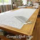 Carmon's Quilt Shop grey Light As Air cotton fabric by Robert Kaufman spread on a large wooden cutting table