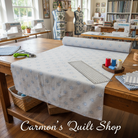 Carmon's Quilt Shop Light As Air grey cotton quilting fabric roll on a wooden table in a sewing studio