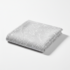 Carmon's Quilt Shop grey 100% cotton quilting fabric with a delicate white floral line art pattern.