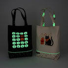 Carmon's Quilt Shop glow-in-the-dark Halloween fabric tote bags with pumpkin, cat, and ghost designs.
