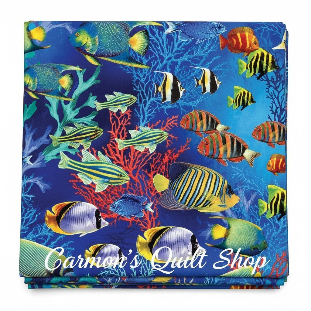 Carmon's Quilt Shop Jewel of The Sea cotton fabric featuring vibrant tropical fish and coral on a deep blue background