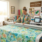 Robert Kaufman Jungle Wide fabric in Fiesta. 100% cotton with a modern geometric and floral design in blue, green, orange, and yellow.