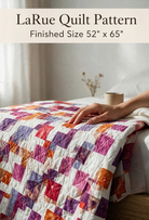 Carmon's Quilt Shop LaRue throw quilt pattern featuring a colorful disappearing nine-patch design on a bed