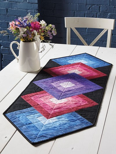 Carmon's Quilt Shop Log Cabin Variations quilt pattern book featuring a colorful geometric table runner project