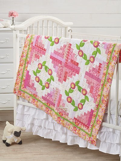 Carmon's Quilt Shop Log Cabin Variations quilt pattern featuring pink floral blocks on a white crib