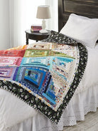 Carmon's Quilt Shop Log Cabin Variations quilt pattern book featuring a colorful patchwork quilt on a bed