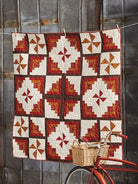 Carmon's Quilt Shop Log Cabin Variations quilt featuring red, orange, and cream geometric fabric patterns.