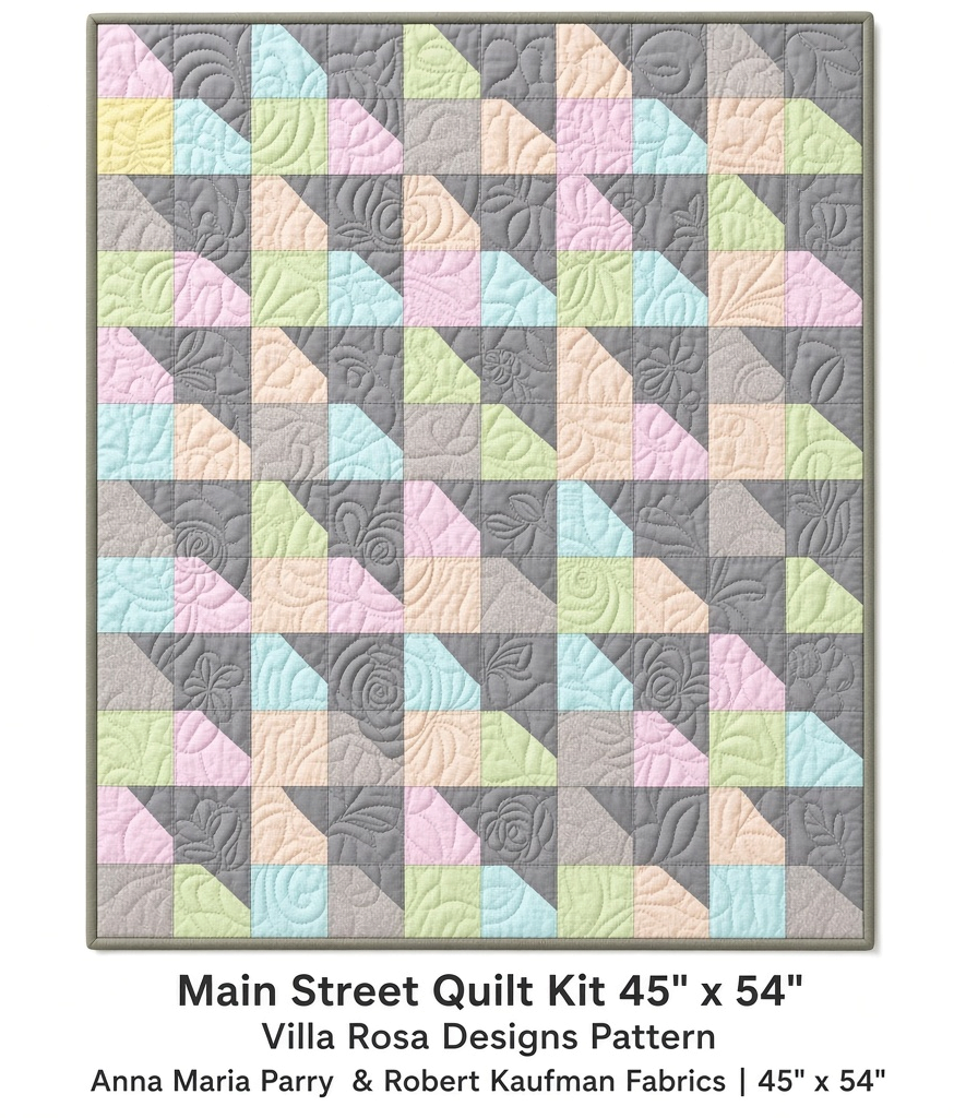 Carmon's Quilt Shop Main Street quilt kit featuring pastel patchwork squares and grey floral quilting on a 45x54 throw