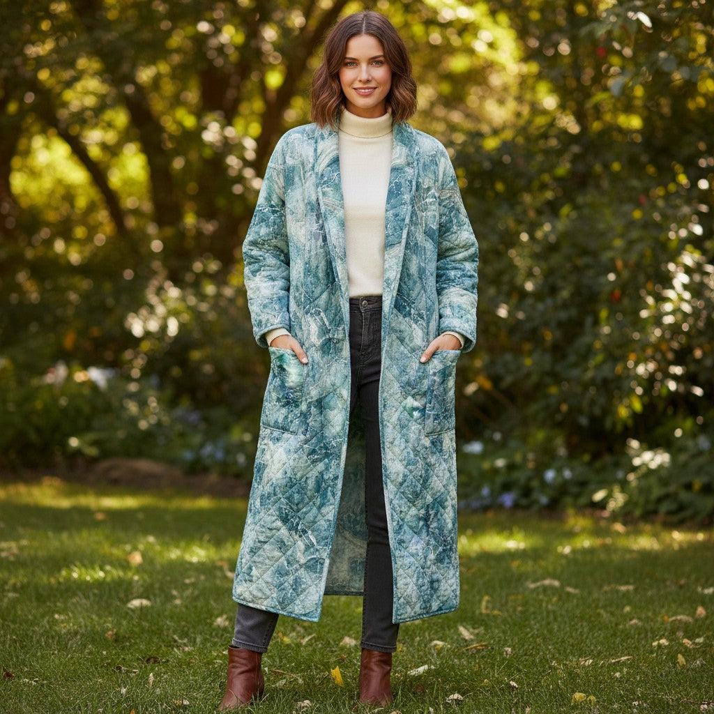 Carmon's Quilt Shop model wearing a long quilted coat made from Northcott Smooth Sailing marble pattern teal fabric
