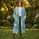 Carmon's Quilt Shop model wearing a long quilted coat made from Northcott Smooth Sailing marble pattern teal fabric