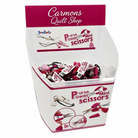 Carmon's Quilt Shop display bin filled with Sew Tasty Purse Power mini scissors featuring pink and white tassels