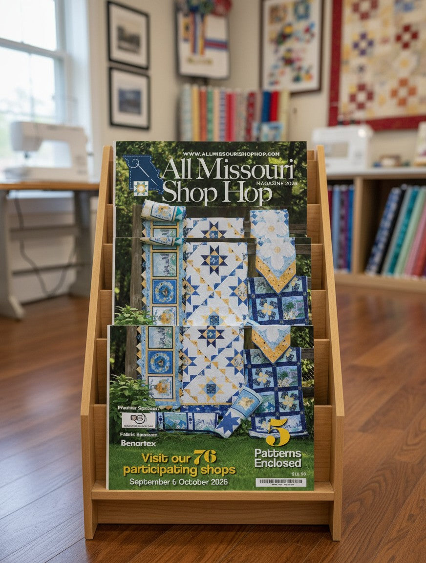 Carmon's Quilt Shop 2026 All Missouri Shop Hop magazine featuring five quilt patterns on a wooden display stand.