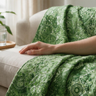 Carmon's Quilt Shop Mystique Blender moss green cotton fabric with intricate floral patterns draped over a sofa.