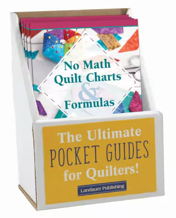 Carmon's Quilt Shop display box containing No Math Quilt Charts & Formulas pocket guides for quilting reference