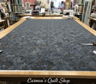 Carmon's Quilt Shop Chroma Obsidian black textured 108-inch wide cotton quilt backing fabric on a cutting table.