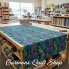 Carmon's Quilt Shop Ocean floral multi-colored 108-inch wide premium cotton quilt backing fabric on a cutting table.
