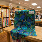 Carmon's Quilt Shop Ocean floral 108-inch wide cotton quilt backing fabric in vibrant blue and green tones.